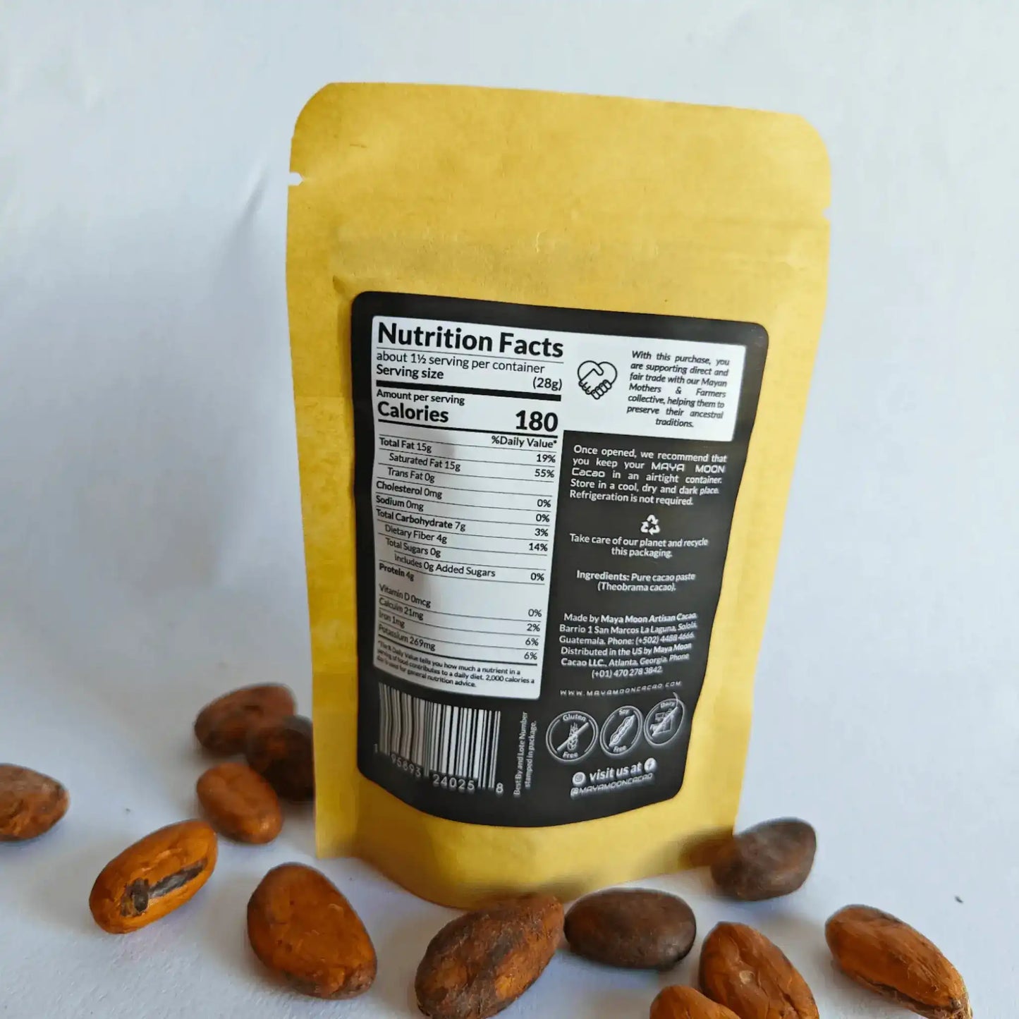 Pure cacao paste in yellow pouch with nutrition facts, surrounded by raw cacao beans from Guatemala