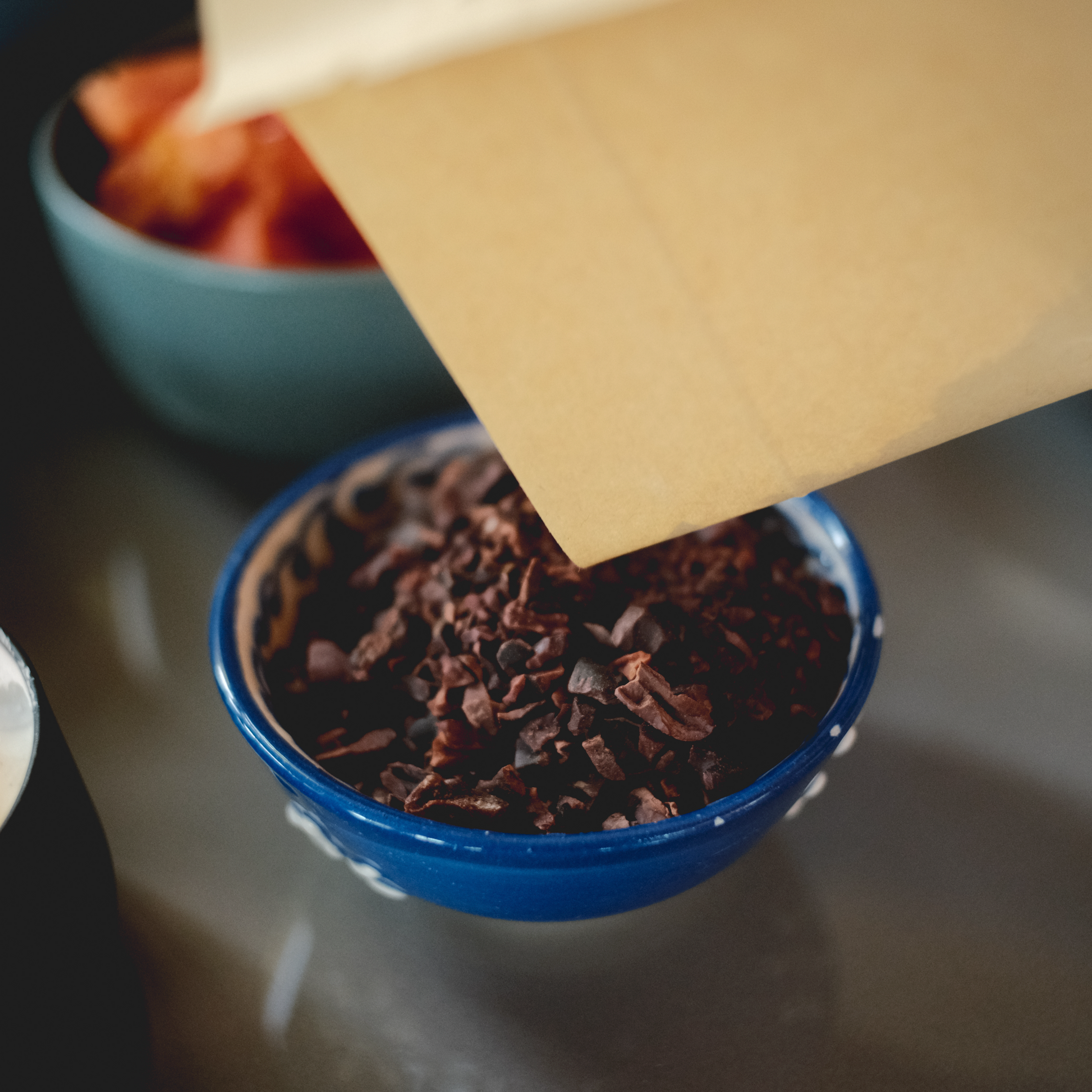 Pouring artisan cacao nibs into a bowl handmade ceremonial cacao from Guatemala 100% chocolate, cocoa