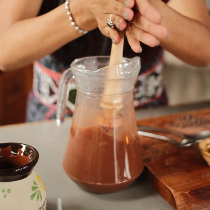Whisking cacao with handmade molinillo for frothy ceremonial drink, chocolate molinillo, cocoa mixer