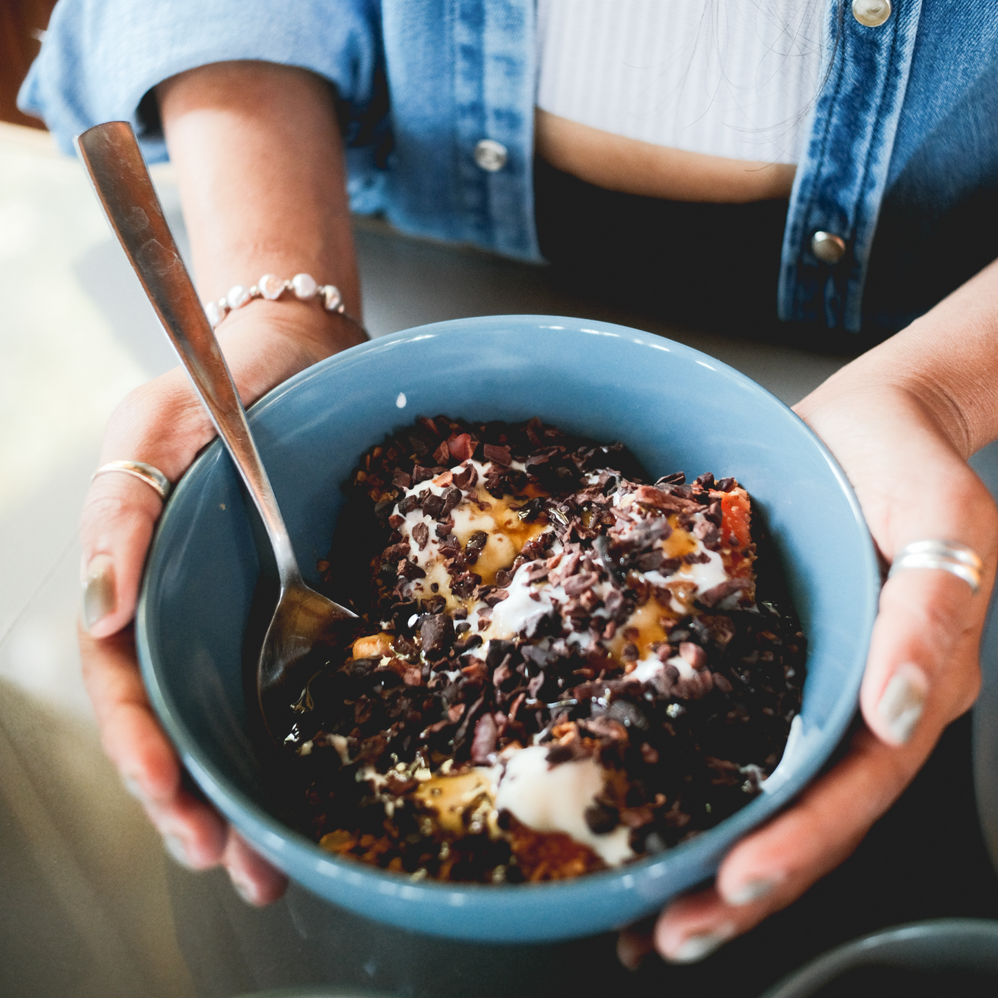 Cacao nibs served in a bowl with fresh fruit and petals ideal for rituals and snacks, 100% dark chocolate, cacoa