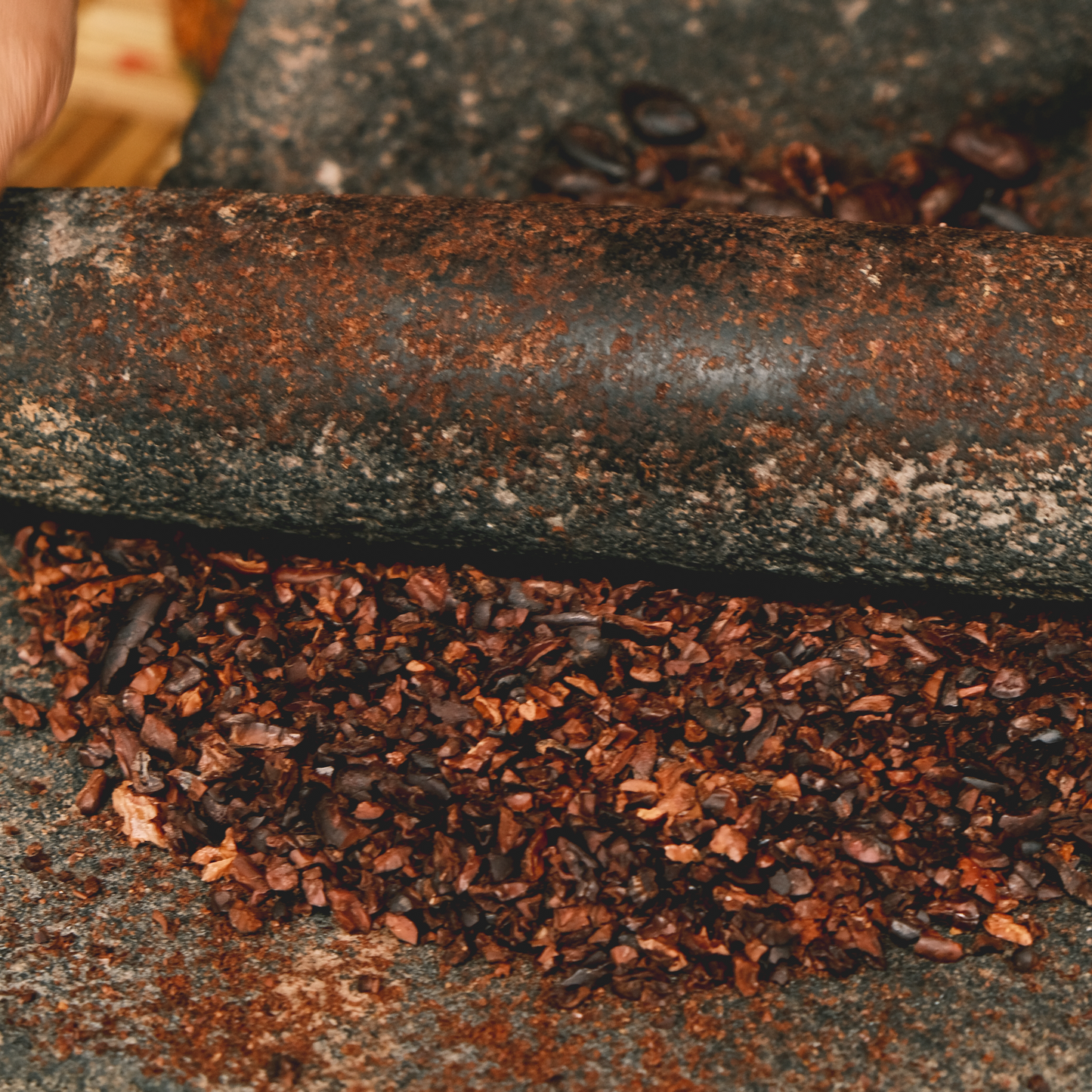 Close-up of cacao nibs on stone grinder crunchy and aromatic ceremonial cacao, 100% dark chocolate, cacoa